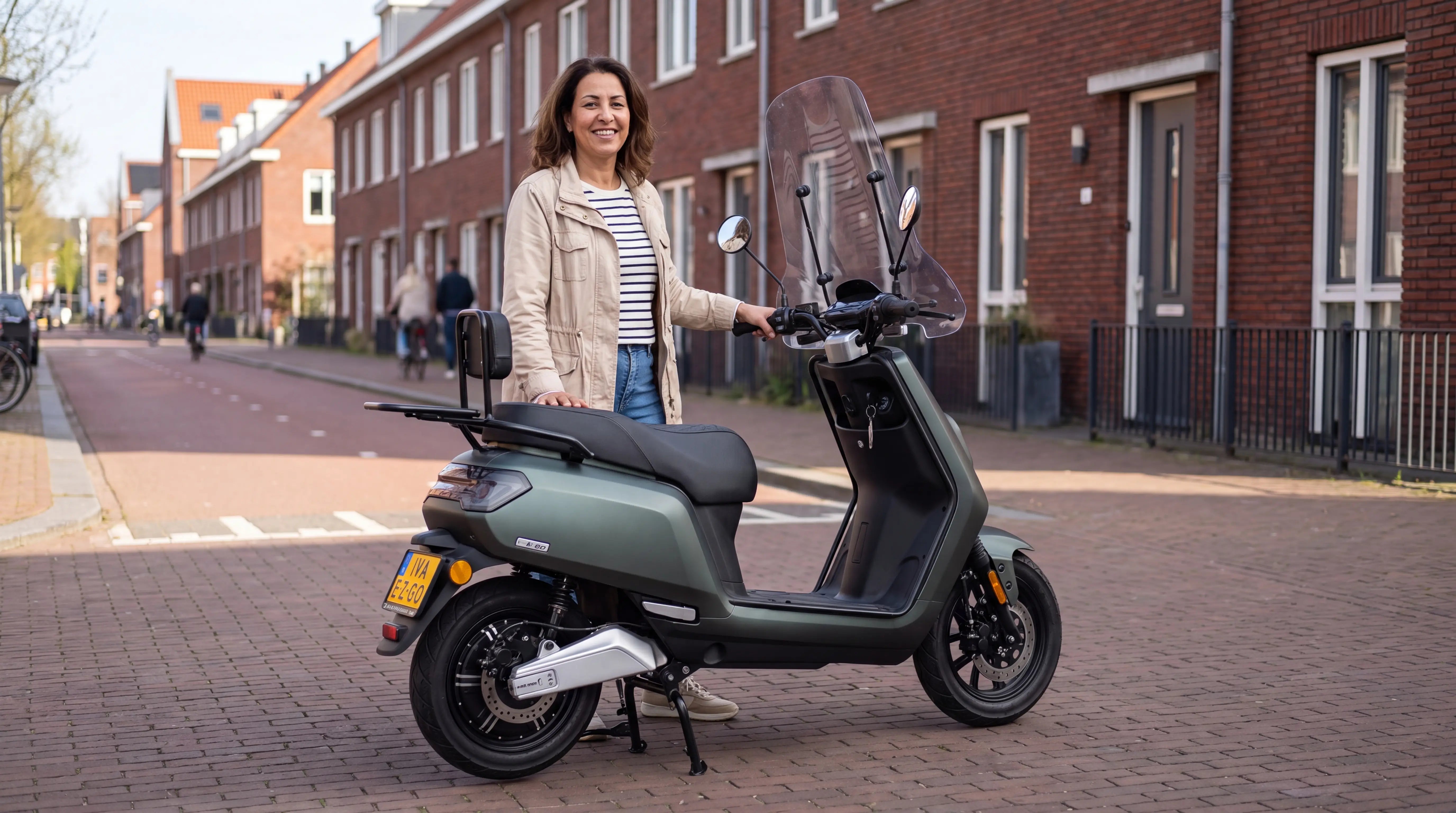 Scooter verzekering 2026: vrouw naast een matgroene IVA E-GO S5 retro scooter in een Rotterdamse straat